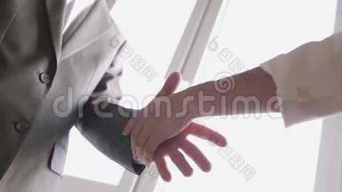 两个生意伙伴在一个穿西装的男人和女人见面时握手。 成功的交易。 慢动作。 3840x2160